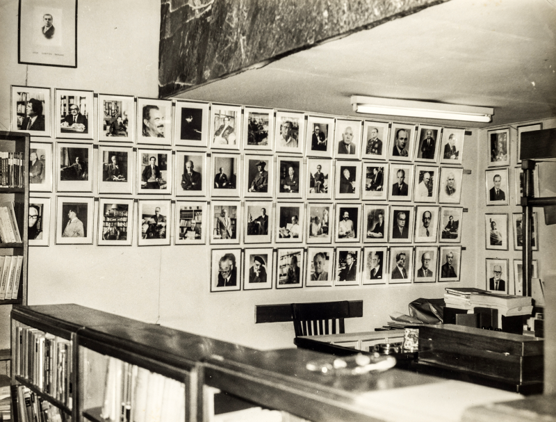 Escritorio de Juan Mejía Baca en su librería del jirón Azángaro. De fondo las míticas fotos que luego donaría a la Biblioteca Nacional del Perú. (Archivo Juan Mejía Baca)